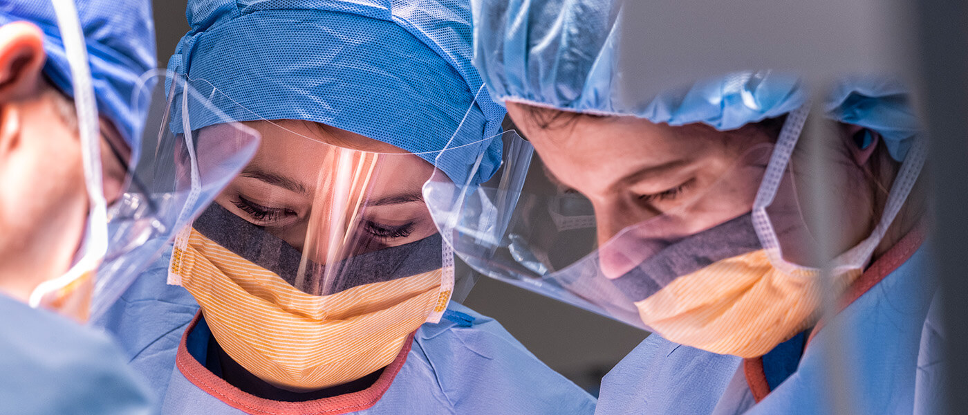 Medical professionals wearing face shields during an operation